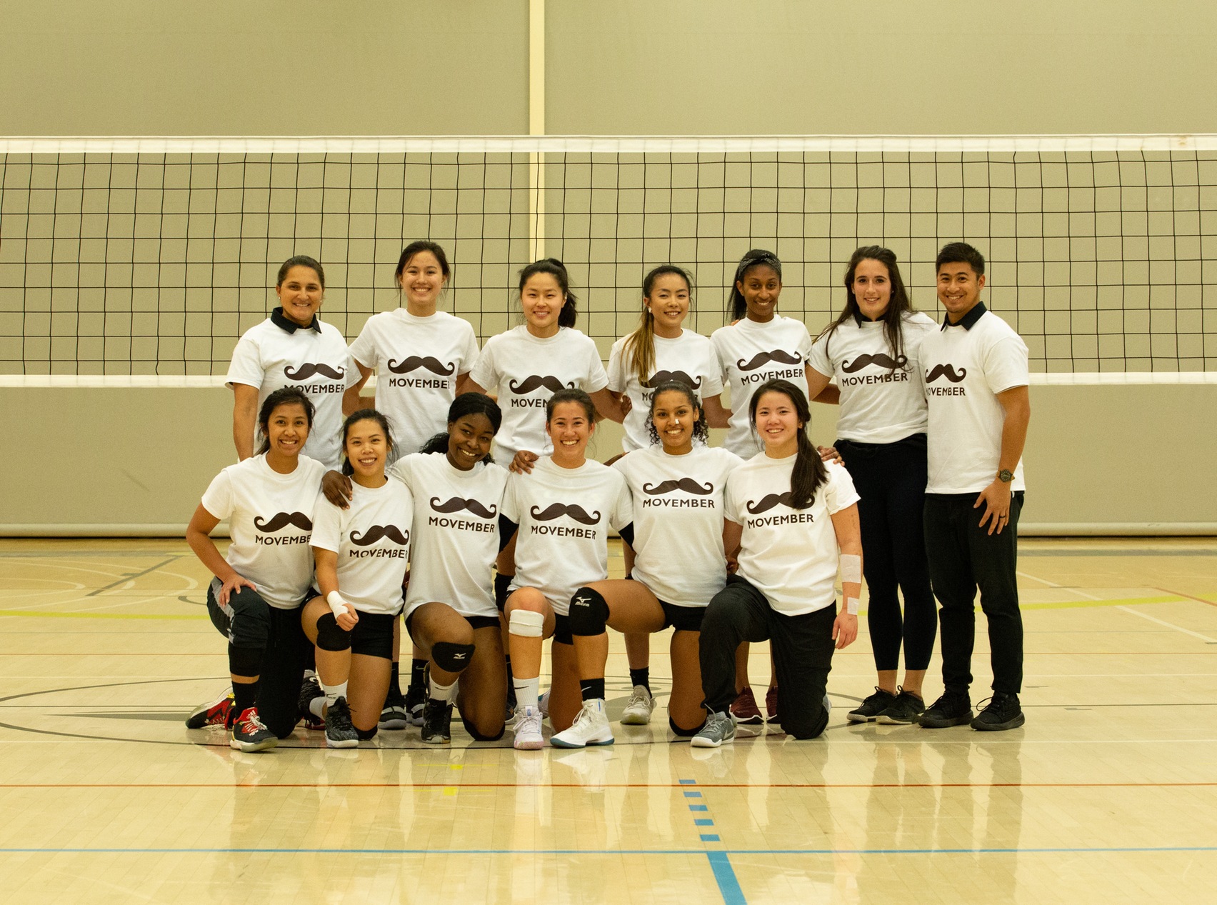 The women's team are all smiles as they take a group photo in their Movember shirts just before their game against the Huskies. Their smiles grew bigger after defeating George Brown in straight sets. (Nicole Ventura/Colts Media)